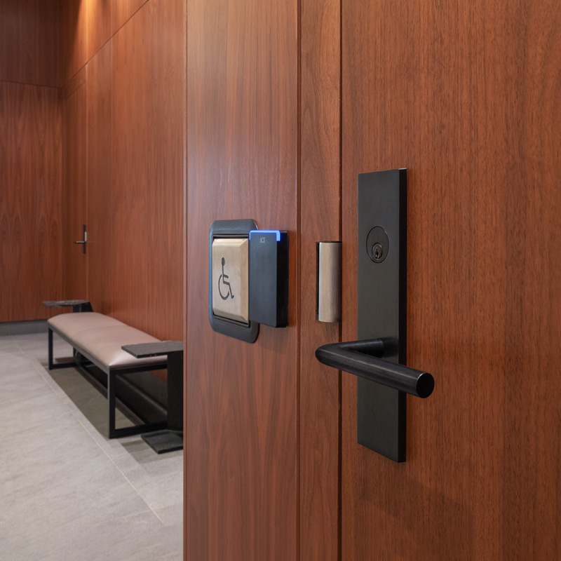 Image of a wooden door with lock, access control reader, and wheelchair button