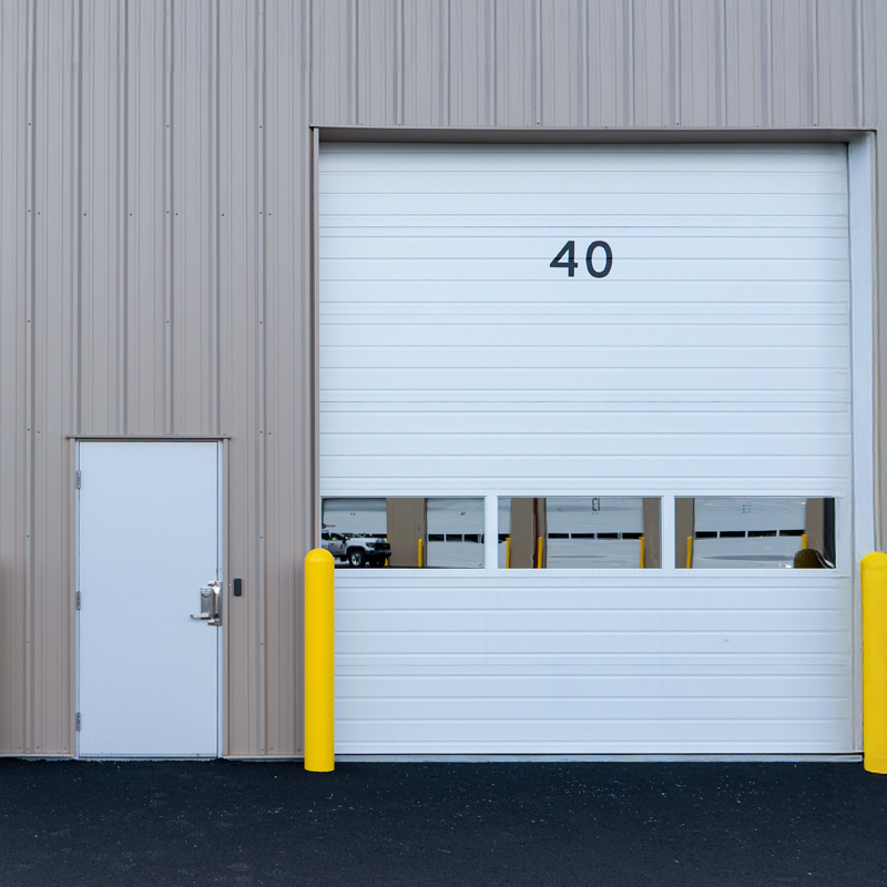 White garage roller door with yellow bollards