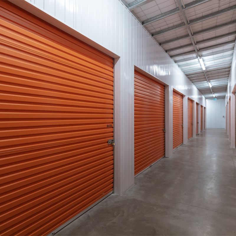 Internal view of self storage facility with multiple orange roller doors