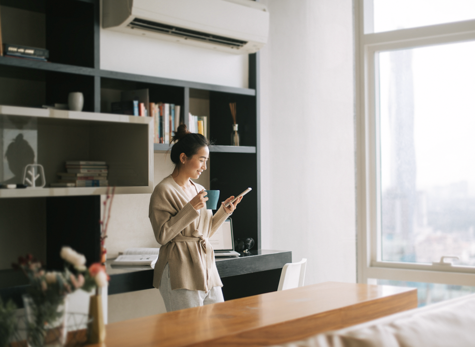 Woman looking at a phone and having a coffee